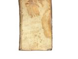 an old book sitting on top of a table next to a white wall