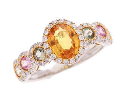 un gros plan d'une bague ornée d'un saphir jaune entouré de pierres multicolores