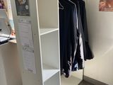 un placard avec des vêtements sur les étagères dans la pièce
