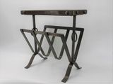 a metal table with a magazine rack on top of it