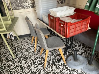 plusieurs chaises et une table dans une pièce au sol carrelé noir et blanc