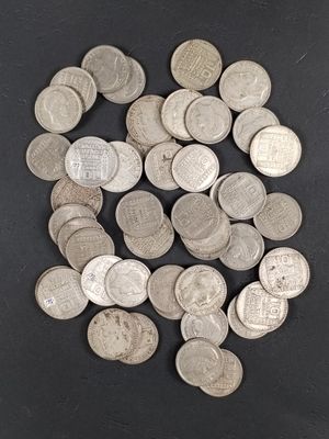 tas de pièces d'argent posées sur une surface noire, sur fond noir