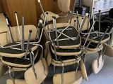 de nombreuses chaises, empilées les unes sur les autres dans une pièce