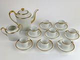 a white and gold tea set with cups and saucers