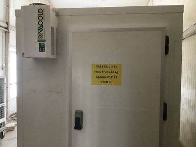 une porte blanche sur laquelle est accrochée une pancarte, dans une pièce