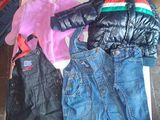 un tas de vêtements posé par terre à côté d'une boîte