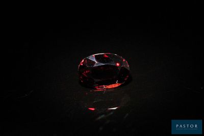 a close up of a red diamond on a black surface