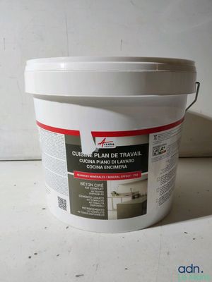 un gros plan sur un seau de peinture posé sur une table