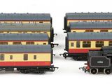 three model trains sitting next to each other on a white surface