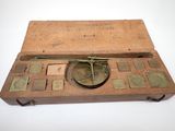 an old wooden box with a clock on top of it on a white surface