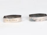 pair of sterling cuff rings with the names of two people on them