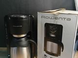 une cafetière posée à côté d'une boîte sur une table