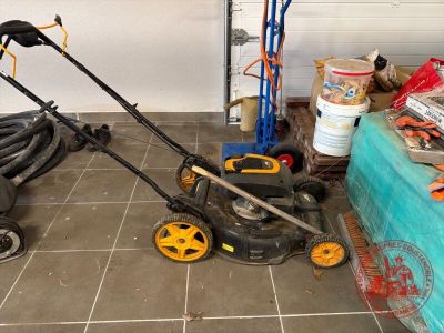 une tondeuse à gazon posée par terre dans un garage
