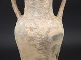un vase très ancien posé sur un socle