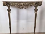 a gold console table with a marble top