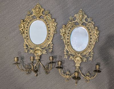 two mirrors and a candle holder on the wall