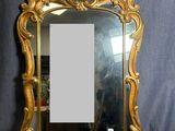 une image représentant un miroir à cadre doré posé sur un tissu bleu