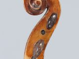 a close up of a violin neck with a fiddle in the background