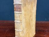 an old book sitting on top of a wooden table next to a blue wall