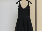 une robe noire suspendue à un portant dans une pièce