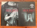 Deux livres posés sur une table en bois : l'un représente un homme et l'autre une femme.