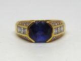 une bague en or jaune sertie d'un saphir bleu et de diamants blancs