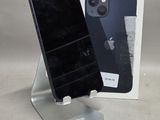 un téléphone noir posé sur un socle à côté d'une boîte blanche