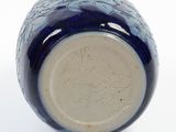a blue and white vase on a white surface