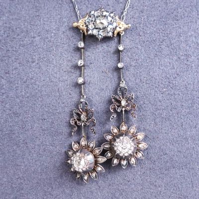a close up of a necklace with a flower design on it