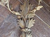 a gold candle holder on a wooden floor with a wooden floor