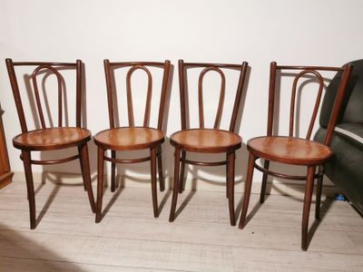four wooden chairs sitting next to each other on a hard wood floor