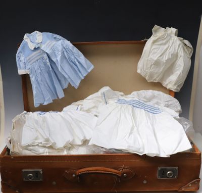 a suit case with a baby ' s clothes inside of it