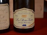 two bottles of wine sitting on a table next to each other