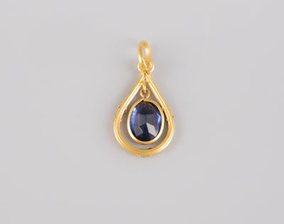 a gold pendant with a blue sapphire stone