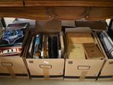many boxes of books sitting on the floor under a desk