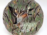 a decorative plate with a bird on it on a white background