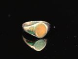 un gros plan d'une bague en argent sertie d'une pierre jaune