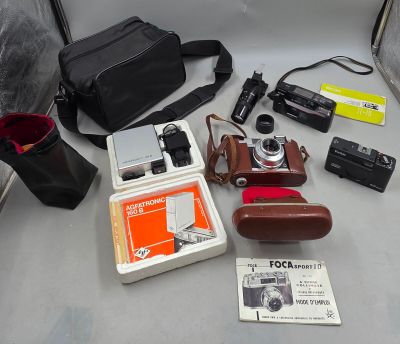 un appareil photo, un étui pour appareil photo, un appareil photo et d'autres objets posés sur une table