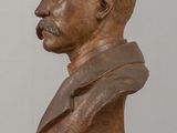 bronze bust of a man with a mustache sitting on a table