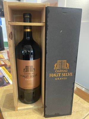 the bottle of chateau haut selve is in a wooden box