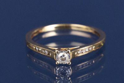 un gros plan d'une bague en diamant posée sur une surface bleue