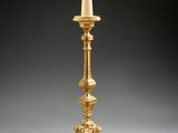 an image of a tall gold candle holder with a crown on top