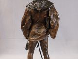 bronze statue of a man with a beard and a hat holding a cane