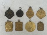 a group of five medals and a medal on a white surface