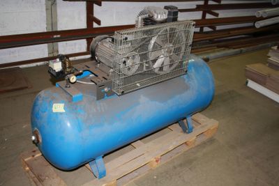 a blue air compressor sitting on a pallet in a warehouse