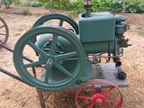 an old green tractor with a red wheel on the ground