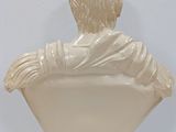 marble bust of a boy in a white shirt sitting on a white pedestal