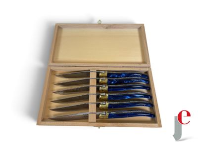 five knives in a wooden box on a white surface