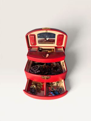 a small red box with a bunch of jewelry inside of it