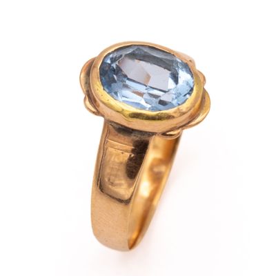 an image of a gold ring with a blue topaz stone